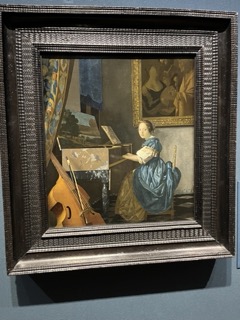 ヴァージナルの前に座る若い女性